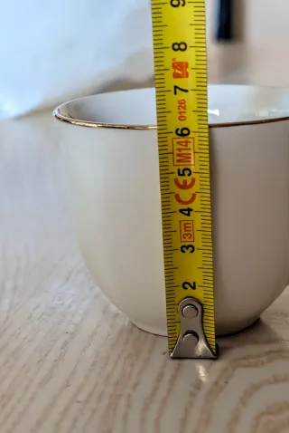 Tazas de café de porcelana con borde dorado.