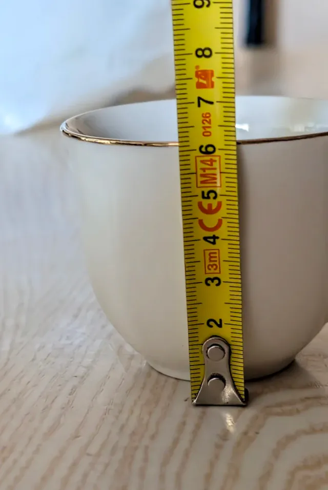 Tazas de café de porcelana con borde dorado.