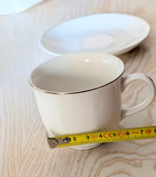 Tazas de café de porcelana con borde dorado.