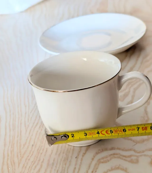 Tazas de café de porcelana con borde dorado.