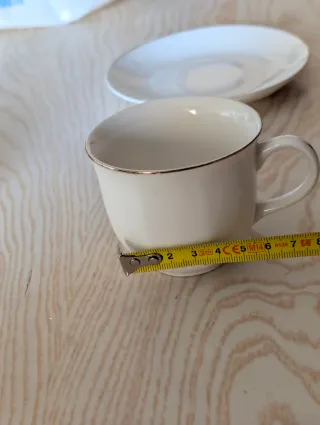Tazas de café de porcelana con borde dorado.