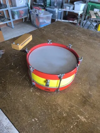 Tambor rojo con bloque de madera