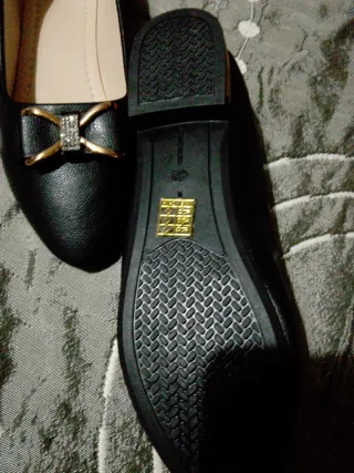 Zapatos negros con detalle dorado