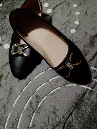 Zapatos negros con detalle dorado