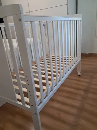 Cuna blanca con colchón de marca Ecus Osxi.