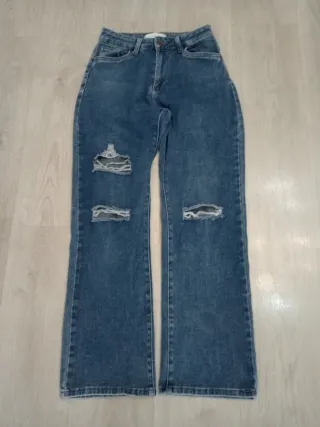 Pantalón vaquero azul con roturas decorativas