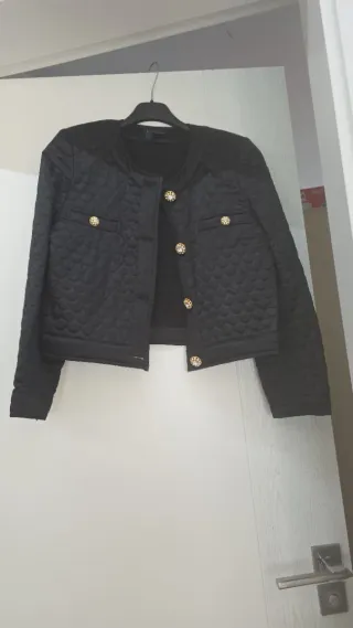Chaqueta negra acolchada con botones dorados