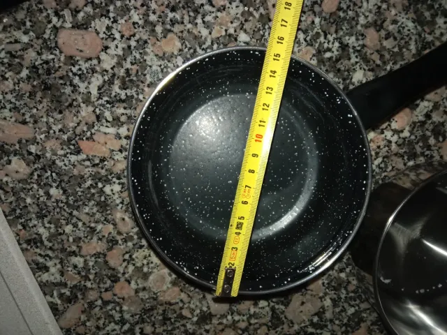 Dos cazos 1 de acero inoxidable y otro negro .