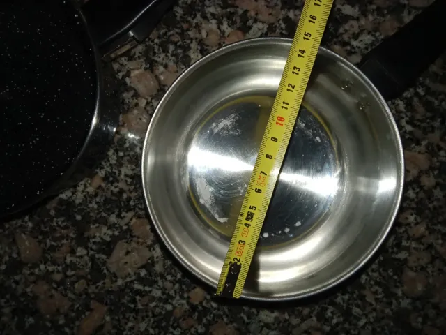 Dos cazos 1 de acero inoxidable y otro negro .