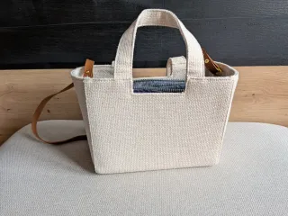 Bolso de tela beige con relleno letras negras