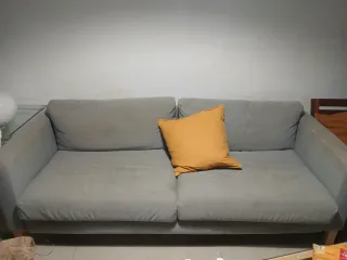 Sofá de 3 plazas gris con cojín amarillo