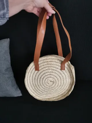 Bolso redondo de paja con asas de cuero
