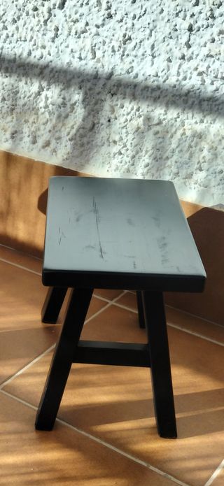 Taburete pequeño de madera de teca, color negro.