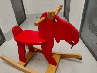 Reno de madera rojo para balancearse