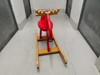 Reno de madera rojo para balancearse