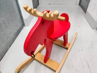 Reno de madera rojo para balancearse