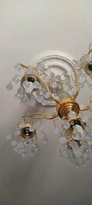 Lámpara araña dorada con lágrimas.
