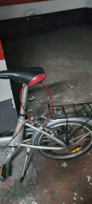 Bicicleta plegable plateada y bici orbea de ciudad