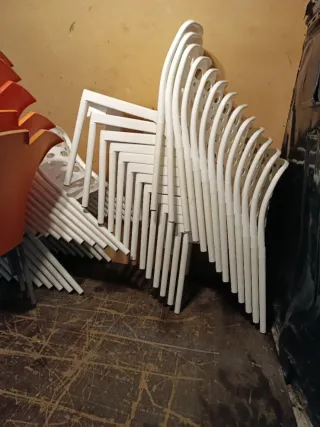 Sillas nuevas apilables blancas y naranjas