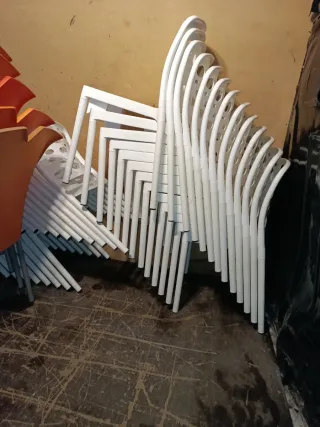 Sillas nuevas apilables blancas y naranjas