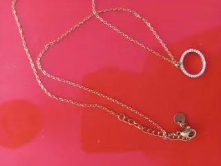 Collar dorado con círculo brillante.