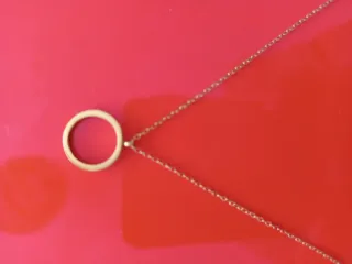 Collar dorado con círculo brillante.