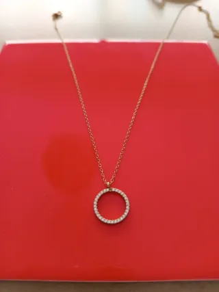 Collar dorado con círculo brillante.