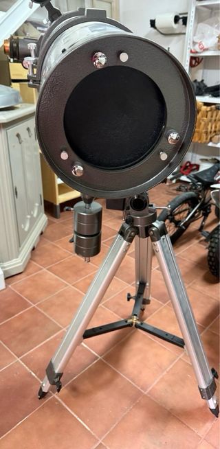 Telescopio plateado con trípode