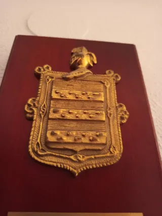 Metopa de madera con escudo dorado