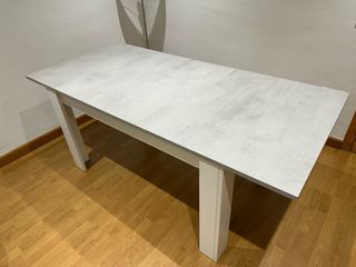 Mesa de comedor extensible gris y blanca.