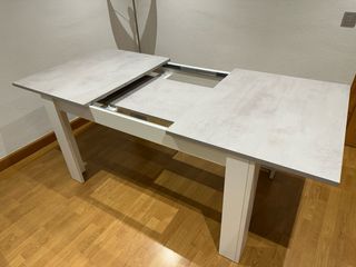 Mesa de comedor extensible gris y blanca.