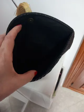 Cartera de mano negra con detalle dorado