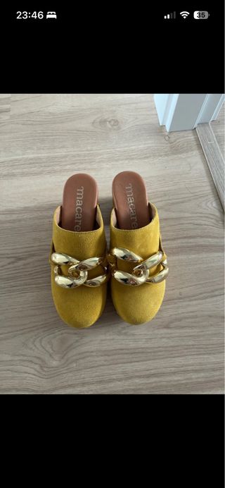 Zuecos amarillos con cadena dorada