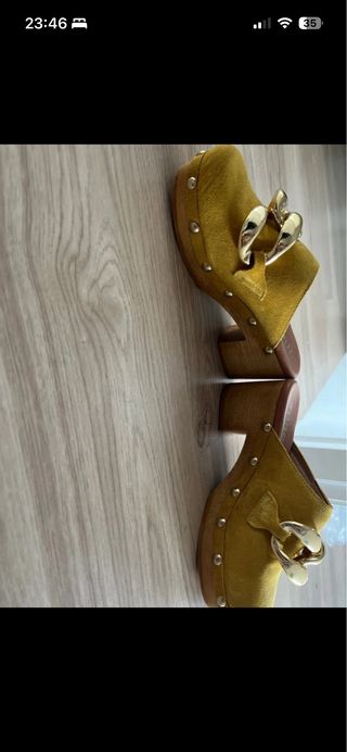 Zuecos amarillos con cadena dorada