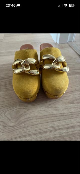 Zuecos amarillos con cadena dorada