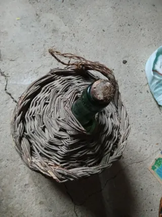 Cesto de mimbre con botella verde