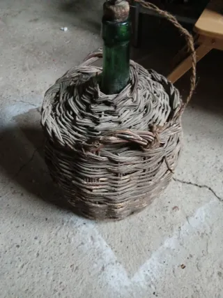 Cesto de mimbre con botella verde