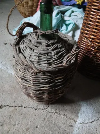 Cesto de mimbre con botella verde