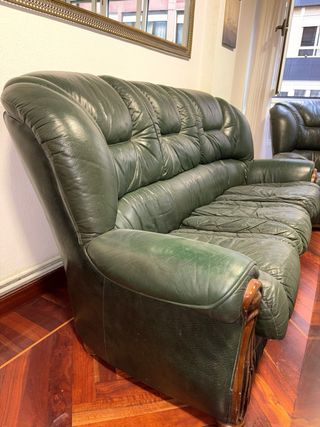 Divano e poltrone in pelle verde.