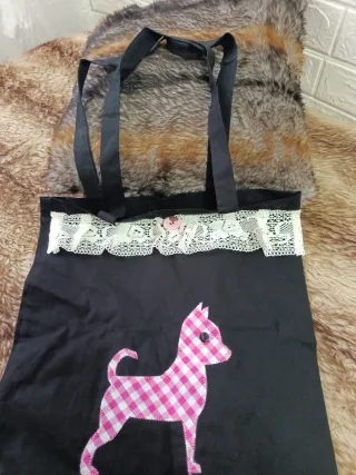 Bolsa de tela negra con perro rosa