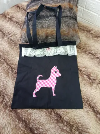 Bolsa de tela negra con perro rosa