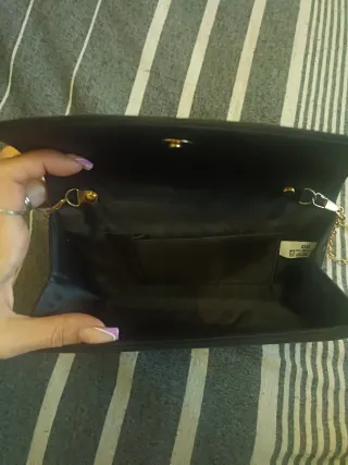 Bolso de mano negro con cadena dorada