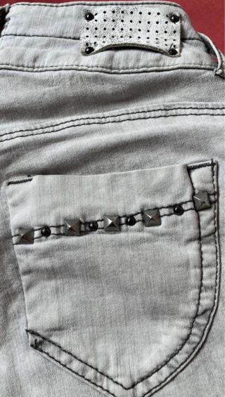 Pantalones vaqueros grises con tachuelas