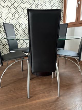 Mesa comedor cristal y 6 sillas negras.
