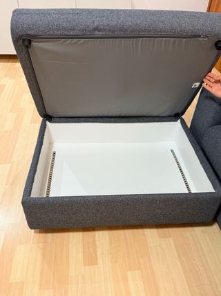 Sofá modular gris con puff de gran capacidad.