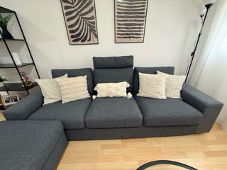 Sofá modular gris con puff de gran capacidad.