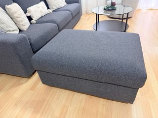 Sofá modular gris con puff de gran capacidad.