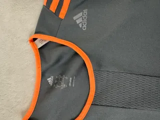 Camiseta deportiva Adidas gris y naranja