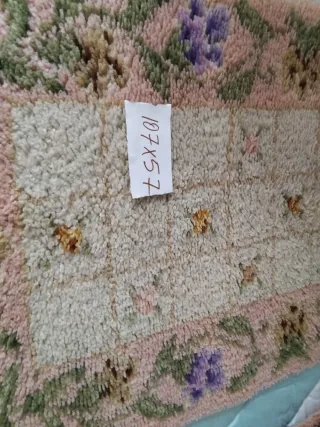 Alfombra de lana rosa con flores como nuevas.