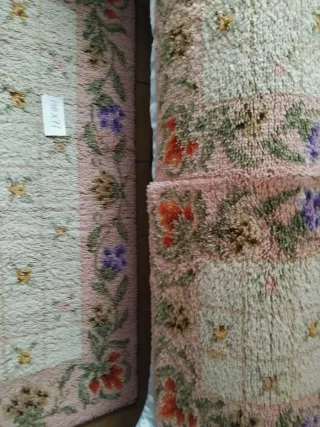 Alfombra de lana rosa con flores como nuevas.